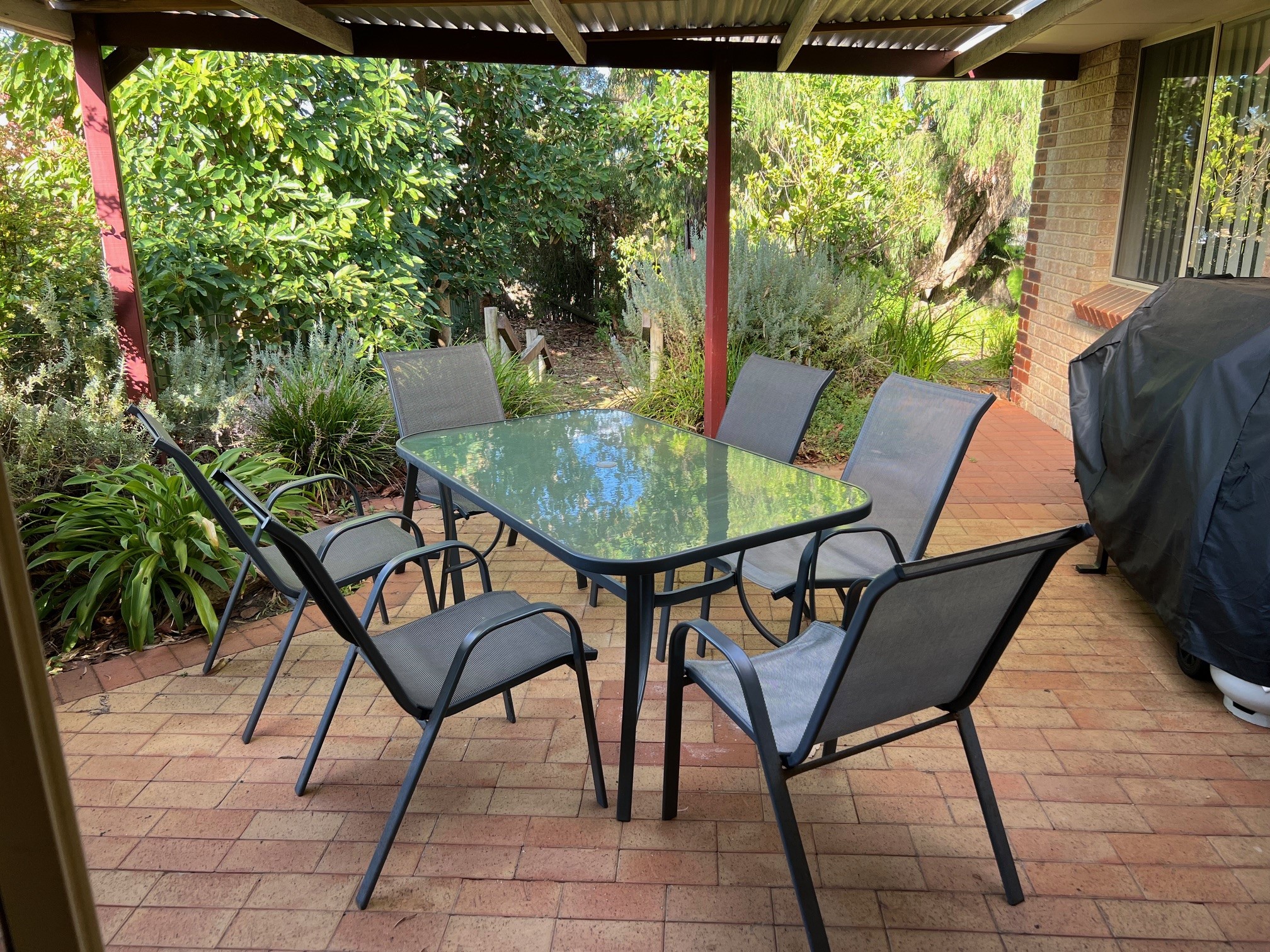 Outdoor dining with large BBQ,  leads down to the lawned area