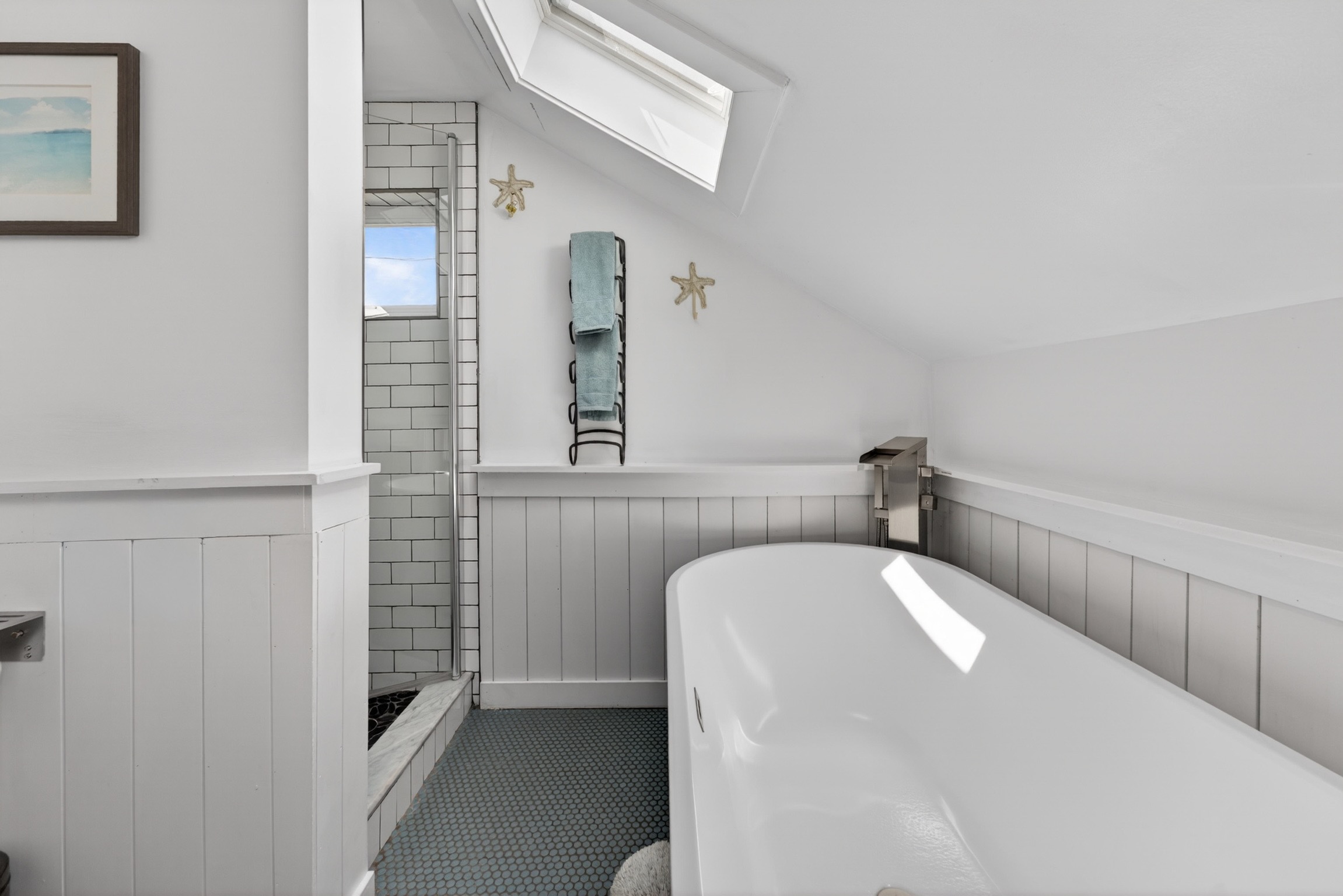 Upstairs full bath features classic penny tile flooring, a walk-in shower, and a large soaking tub perfect for relaxing after a day at the beach.