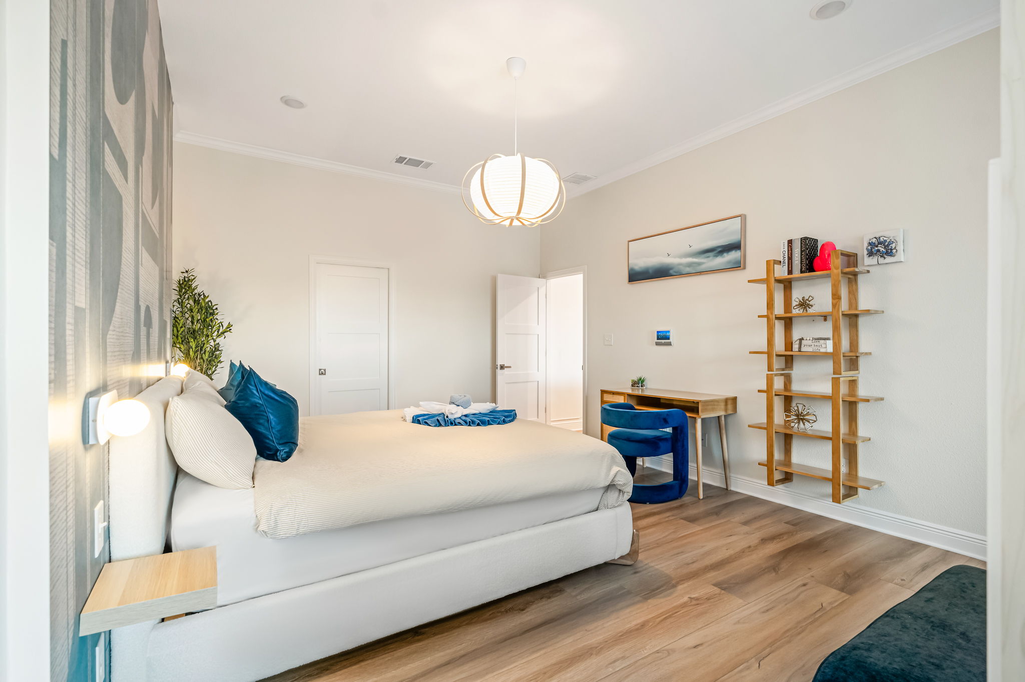 Another view of the luxurious primary bedroom with comfortable king bed and warm lighting.