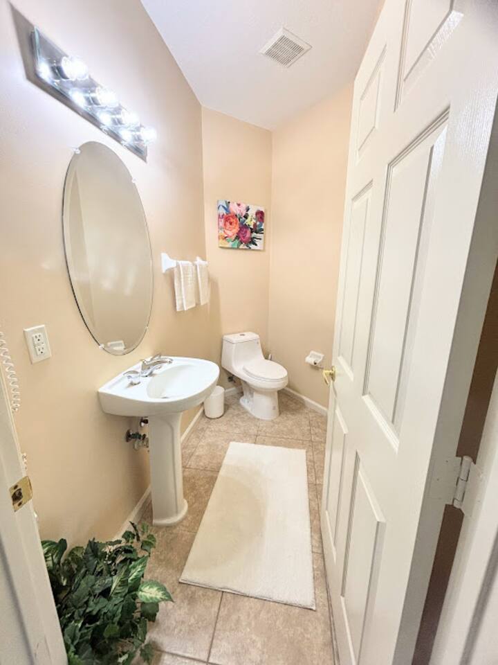 Convenient half bathroom with pedestal sink, tile flooring, and clean neutral finishes.
