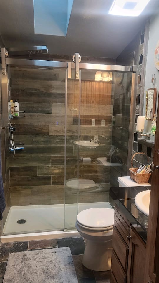 Waterfall shower in guest bathroom next to King guest room and bunk bed room