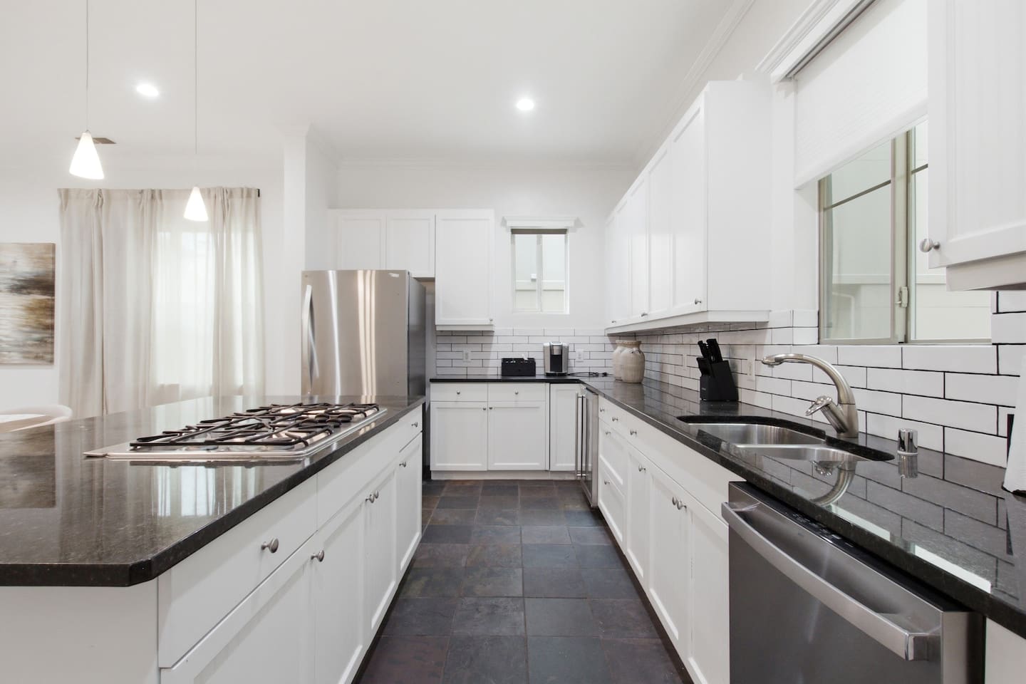 Gas cooktop with stainless range hood and full oven below. Fully outfitted with cookware and utensils for guests who want to cook in and skip the restaurant tab for a night.
