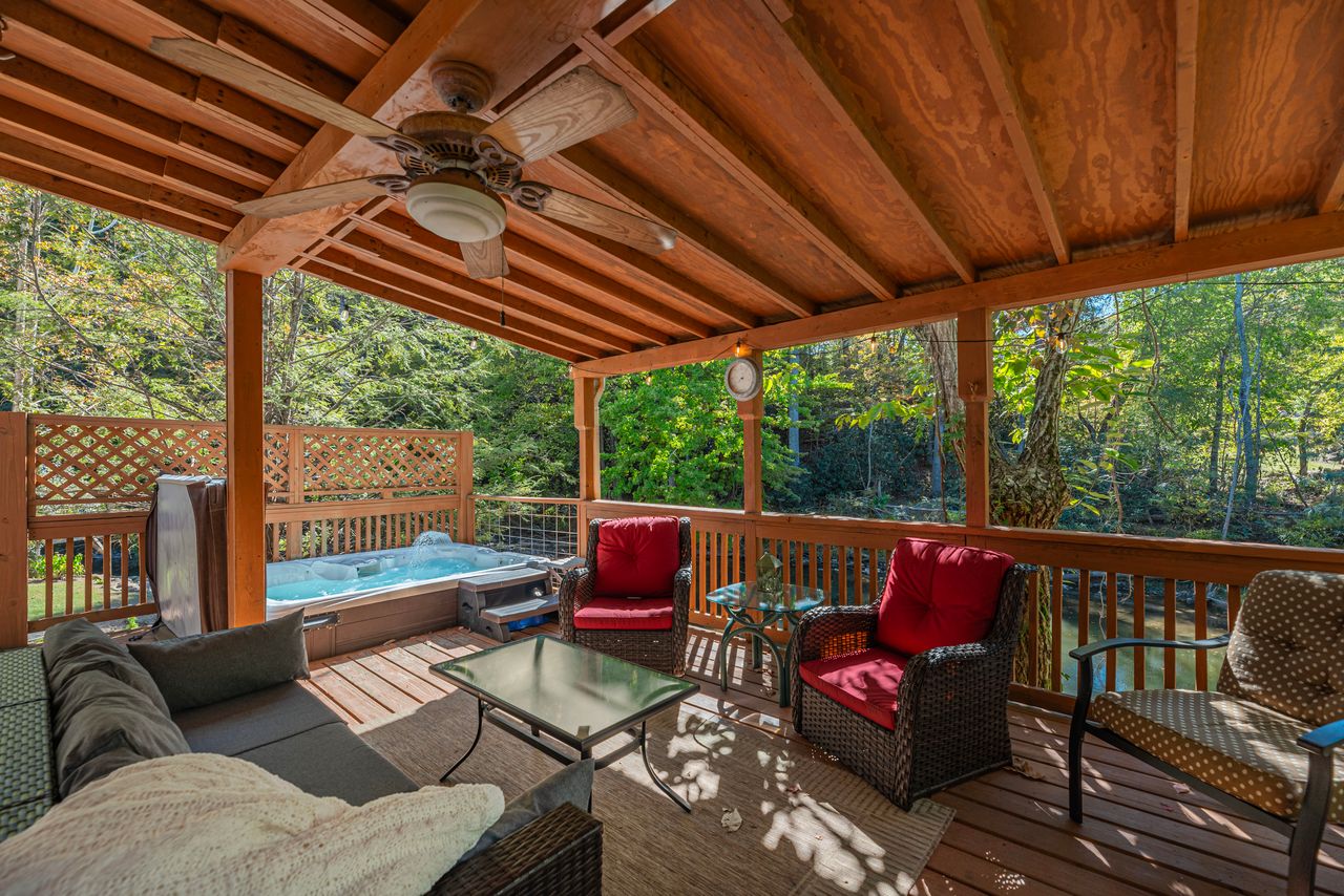 The back deck is amongst the trees, offering guest privacy while taking a dip in the hot tub.