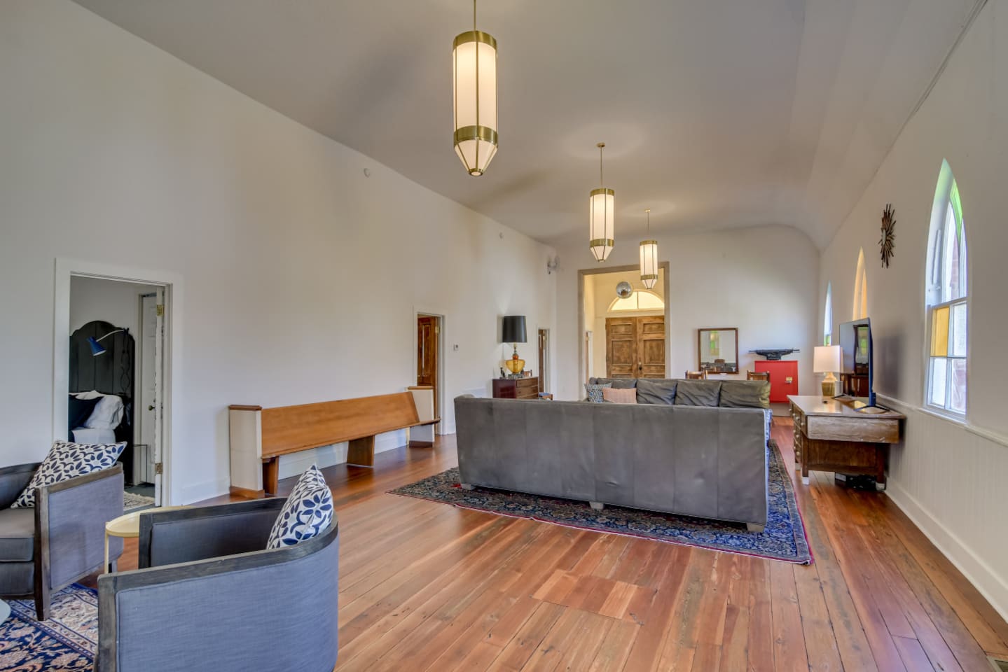 Bright living room with vintage rug and large windows.