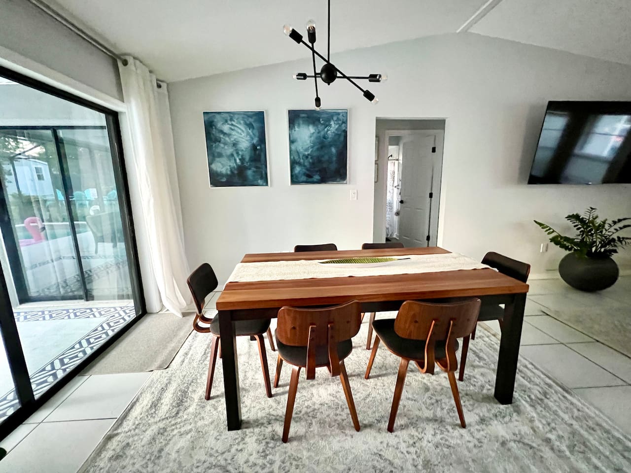Dining table conveniently located near the kitchen and at an angle where the large Roku tv can also be watched 