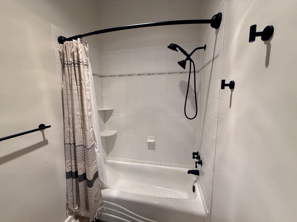 Large full ensuite bathroom attached to the second bedroom with updated fixtures, heat lamp, elongated oval toilet, high ceilings.