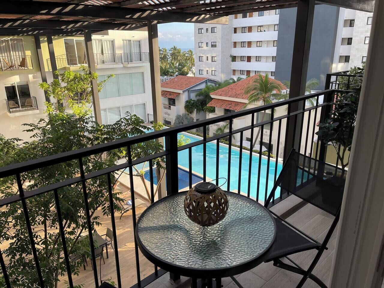 Small balcony overlooking the pool and a peek a boo of the ocean. small table and 2 chairs 320