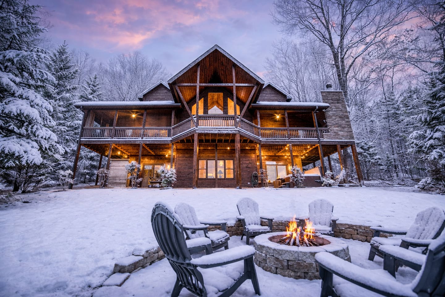 SNOW! The back of the beautiful "Blessed Sunset" mountain retreat home overlooking the back yard! Stunning A-frame, wrap-around porch, screened-in patio, outdoor fireplace, outdoor dining table, sauna, hot tub, outdoor couch, and more!