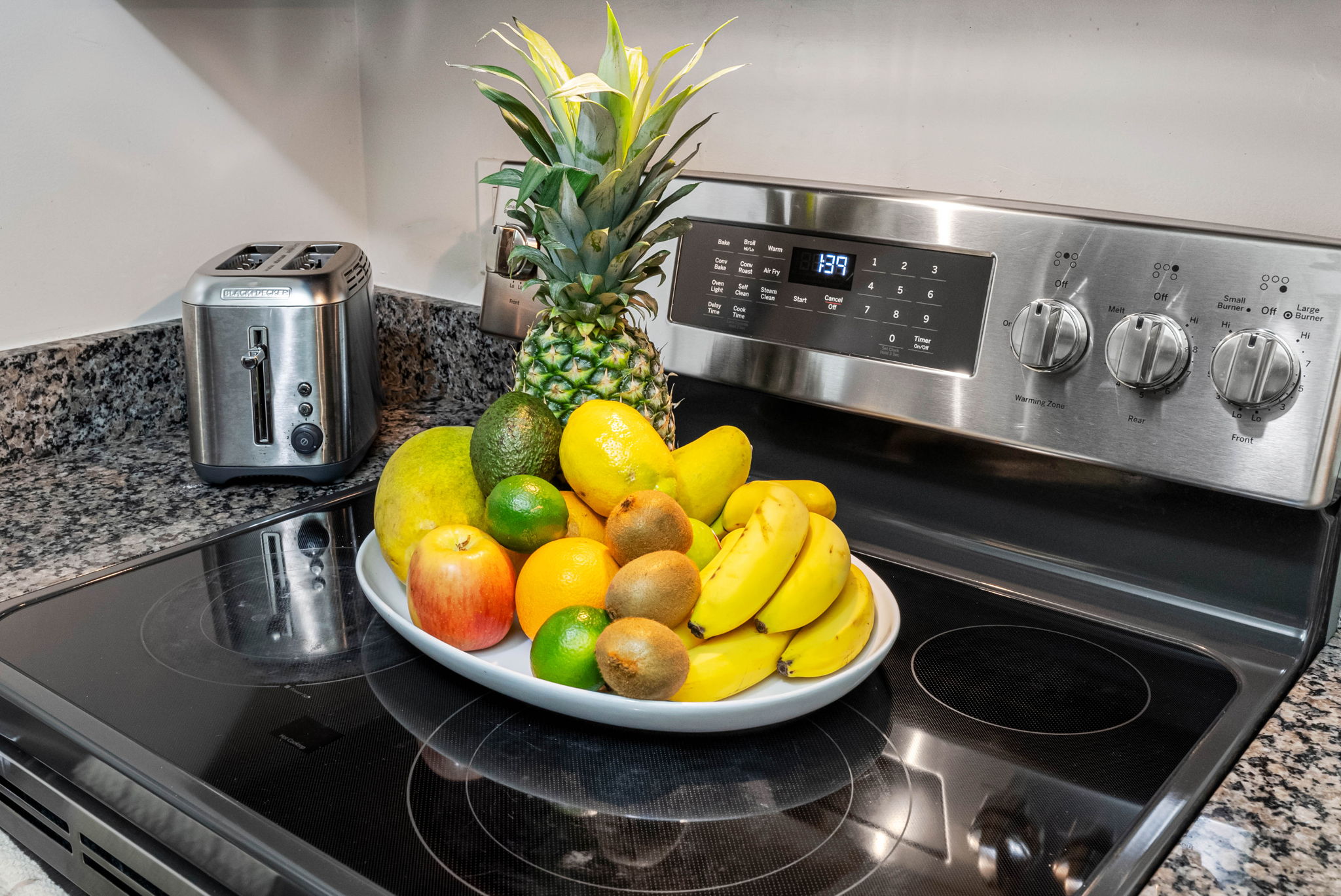 The kitchen boasts a full-size stainless steel stove and oven, topped with a matching microwave, perfect for cooking everything from a quick breakfast to a full dinner.