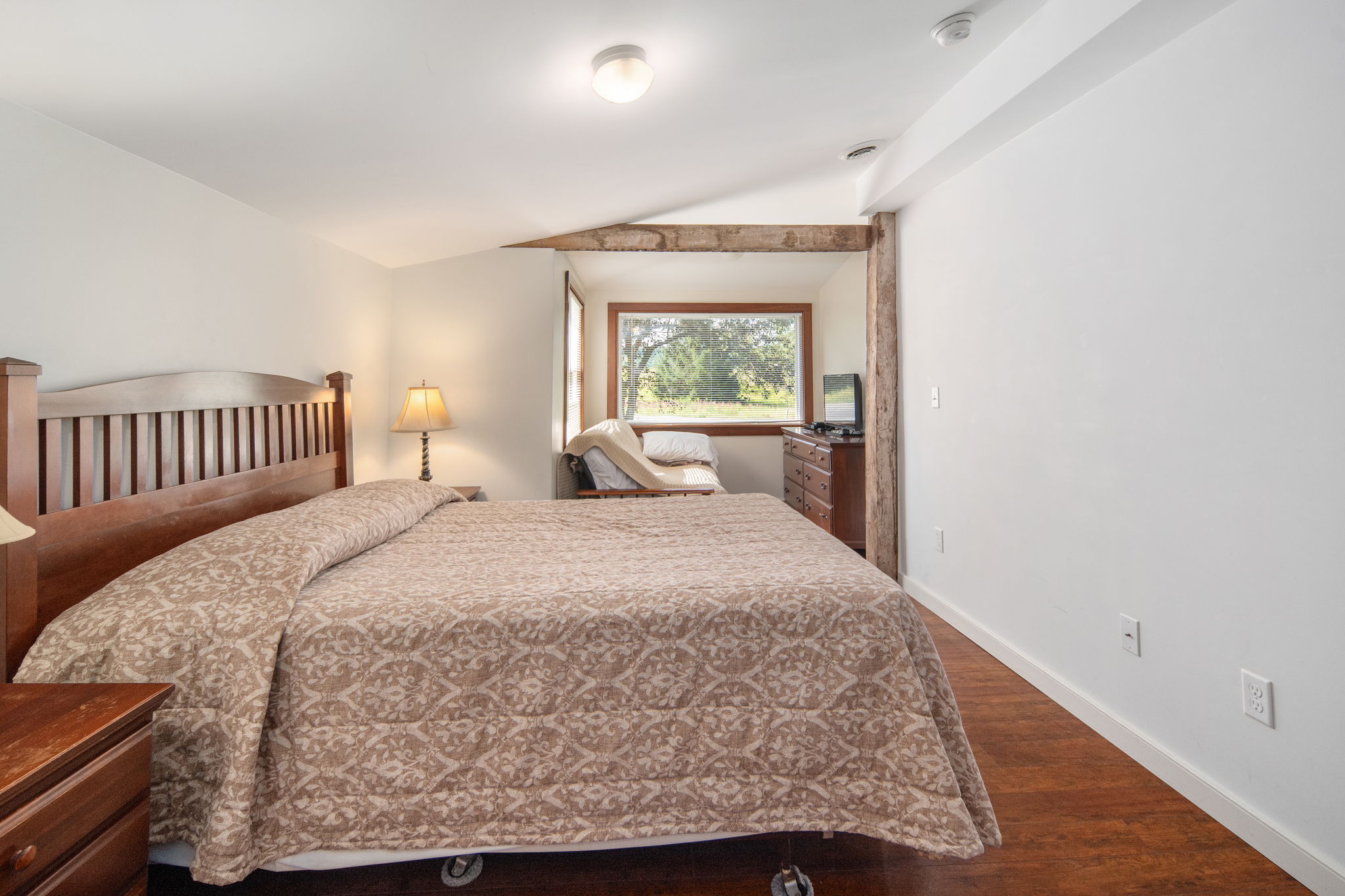 Warm wood details and leafy views create a restful bedroom setting.