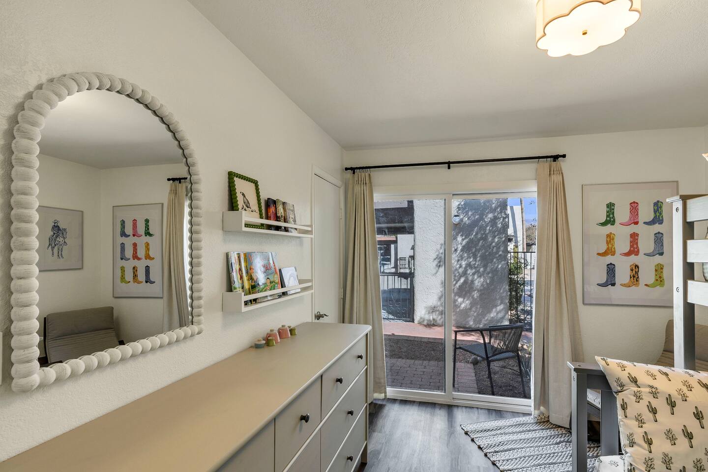 Kids bedroom with books, toys, and mirror.