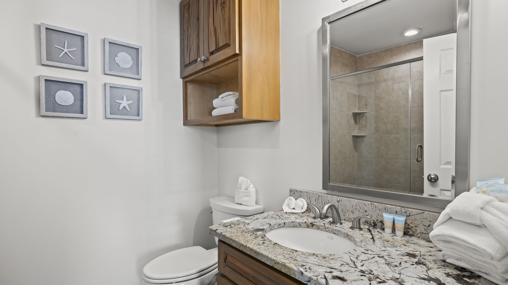 Step into the updated master en suite of our Cotton Bayou condo, featuring modern finishes, dual shower heads for a spa-like experience, and a tranquil atmosphere. The perfect complement to the spacious master suite.