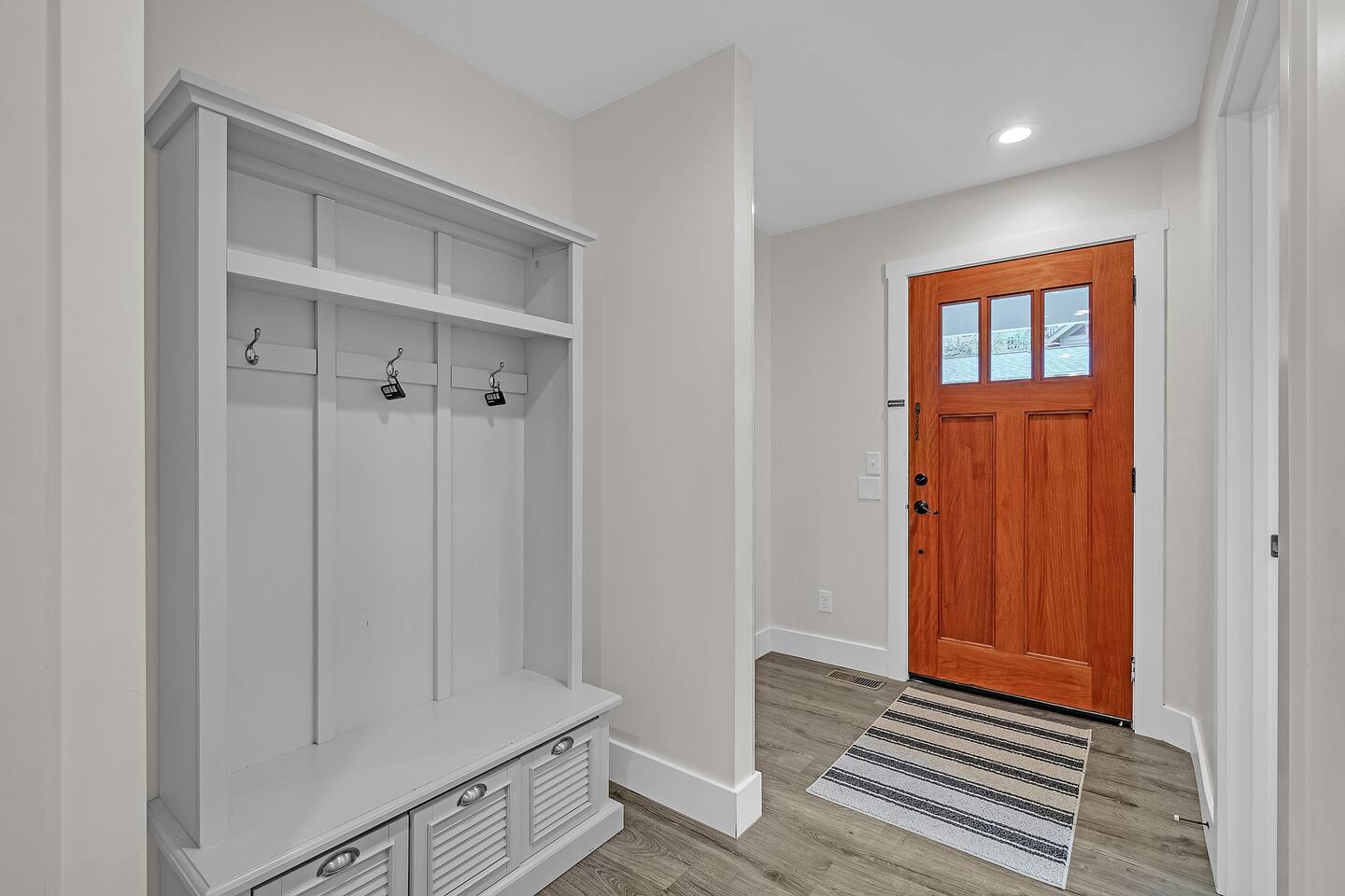 Large entryway with coat hangers and shoe storage.