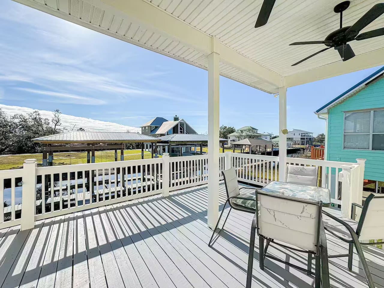Breezy covered deck with outdoor seating and relaxing neighborhood views—perfect for morning coffee or sunset dinners.