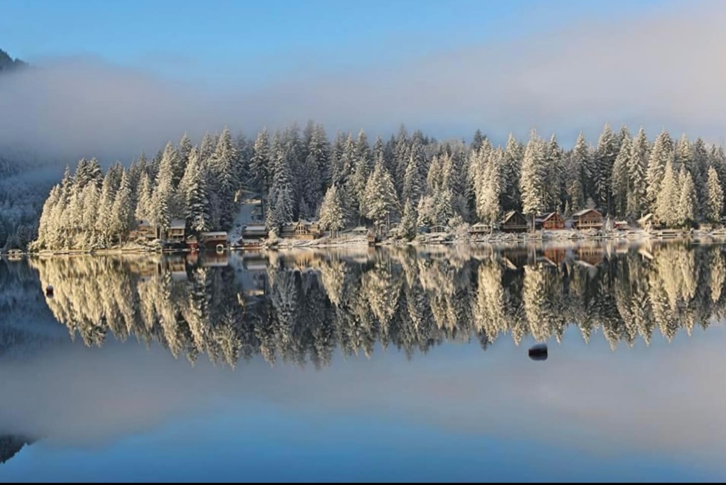 Snow-covered landscape reflecting in the lake
