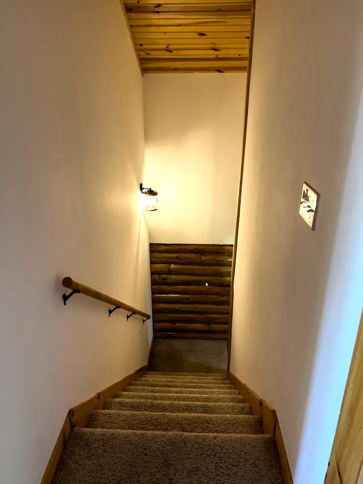Stairs from the upper level heading to and from the kitchen