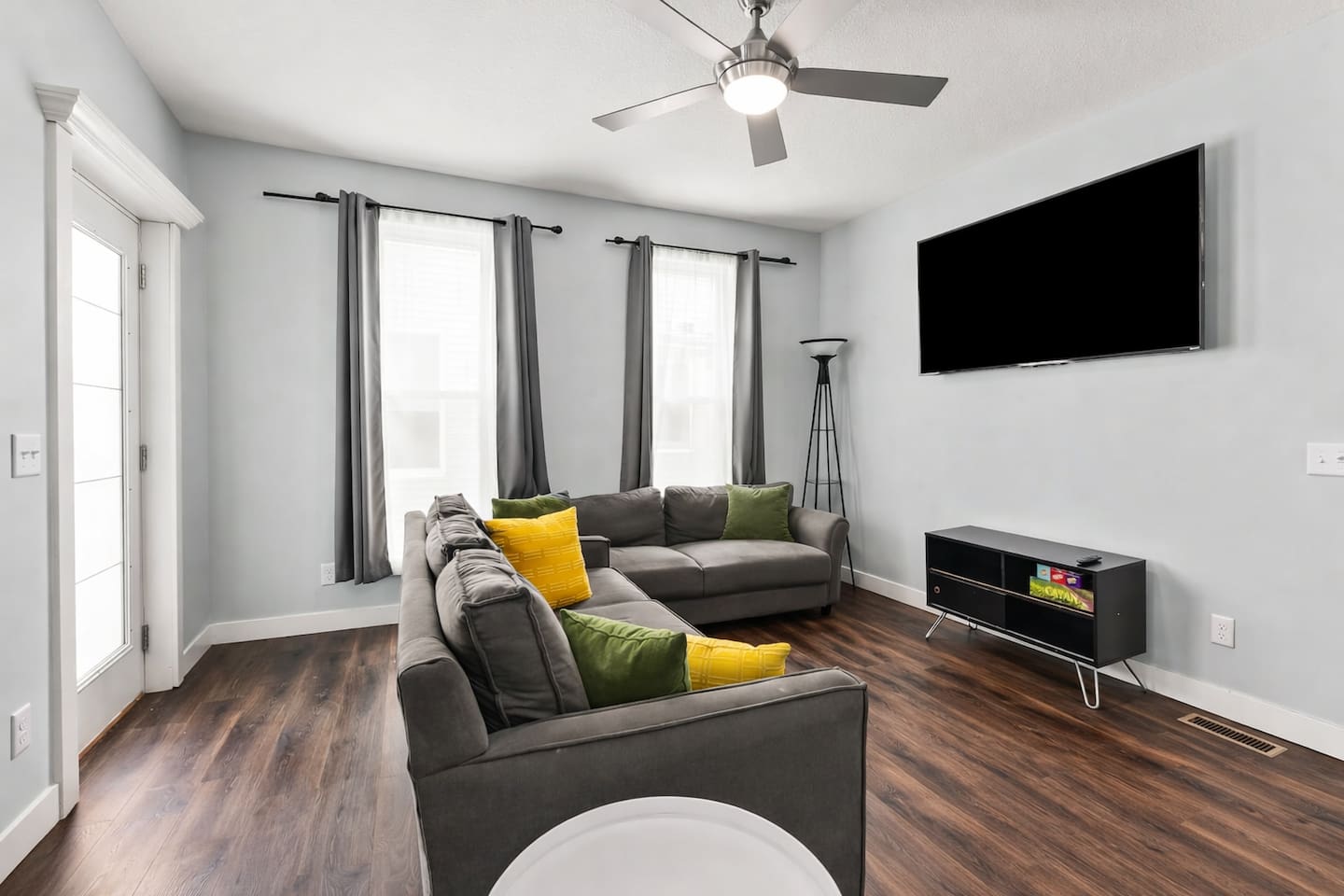 Unwind in the cozy living area featuring plush sofas, a large wall-mounted TV, and plenty of natural light.
