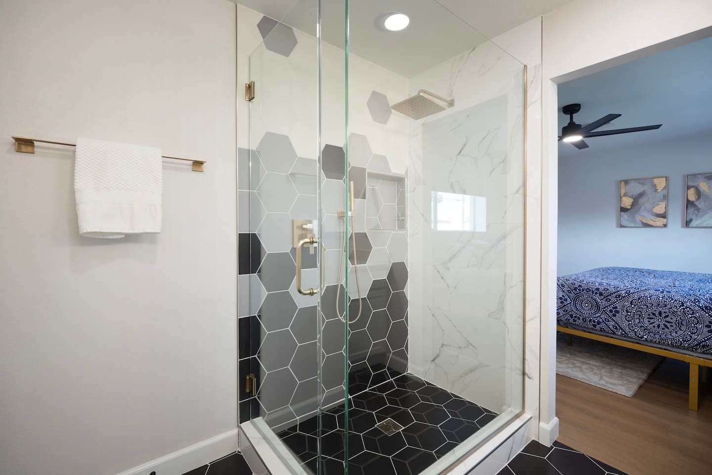 Sleek glass walk-in shower with bold hex tile and marble accents—where modern design meets everyday comfort.