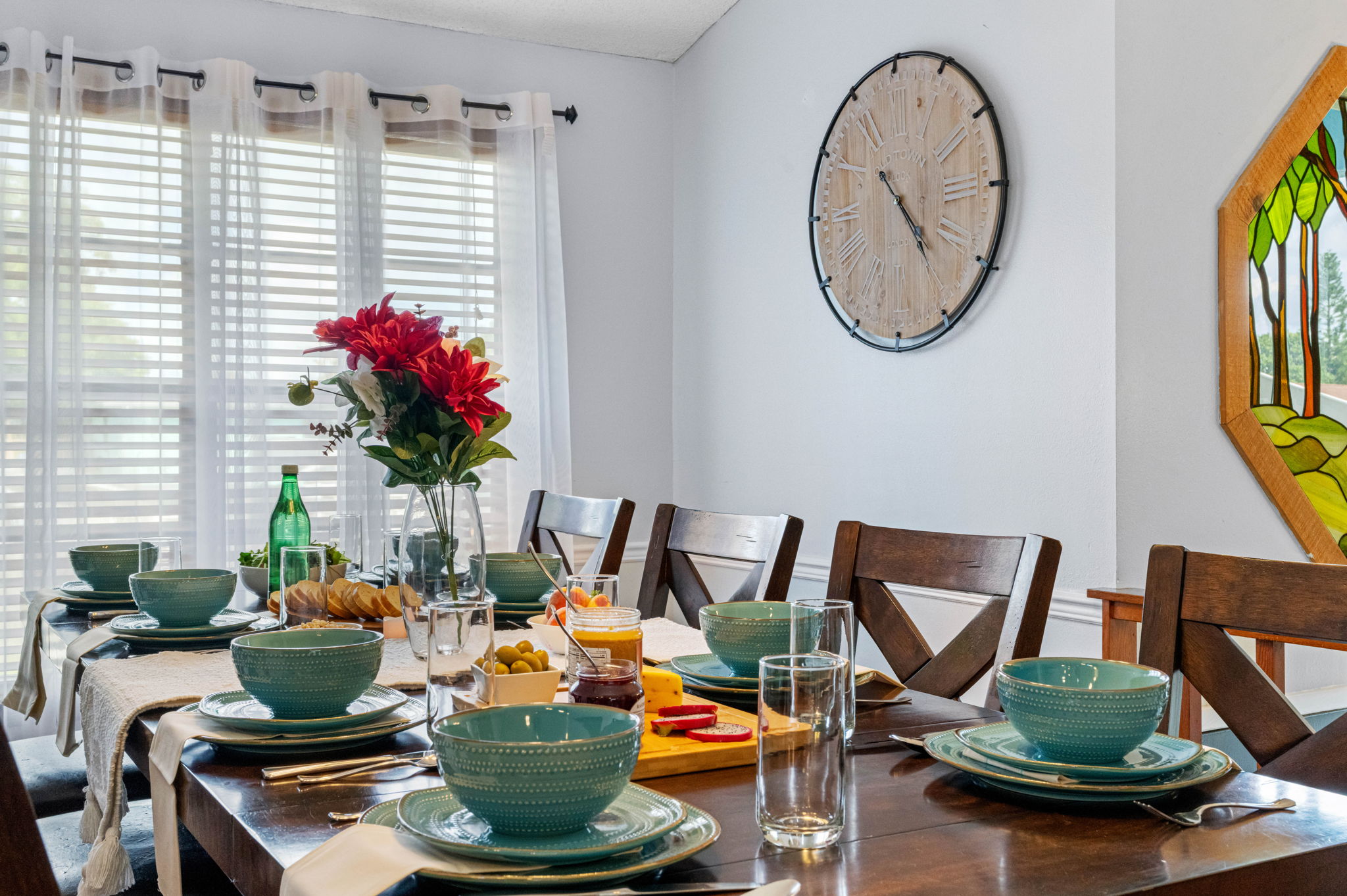 Enjoy comfort and style with this large, wood-finished dining table featuring cushioned chairs and beautiful natural lighting.
