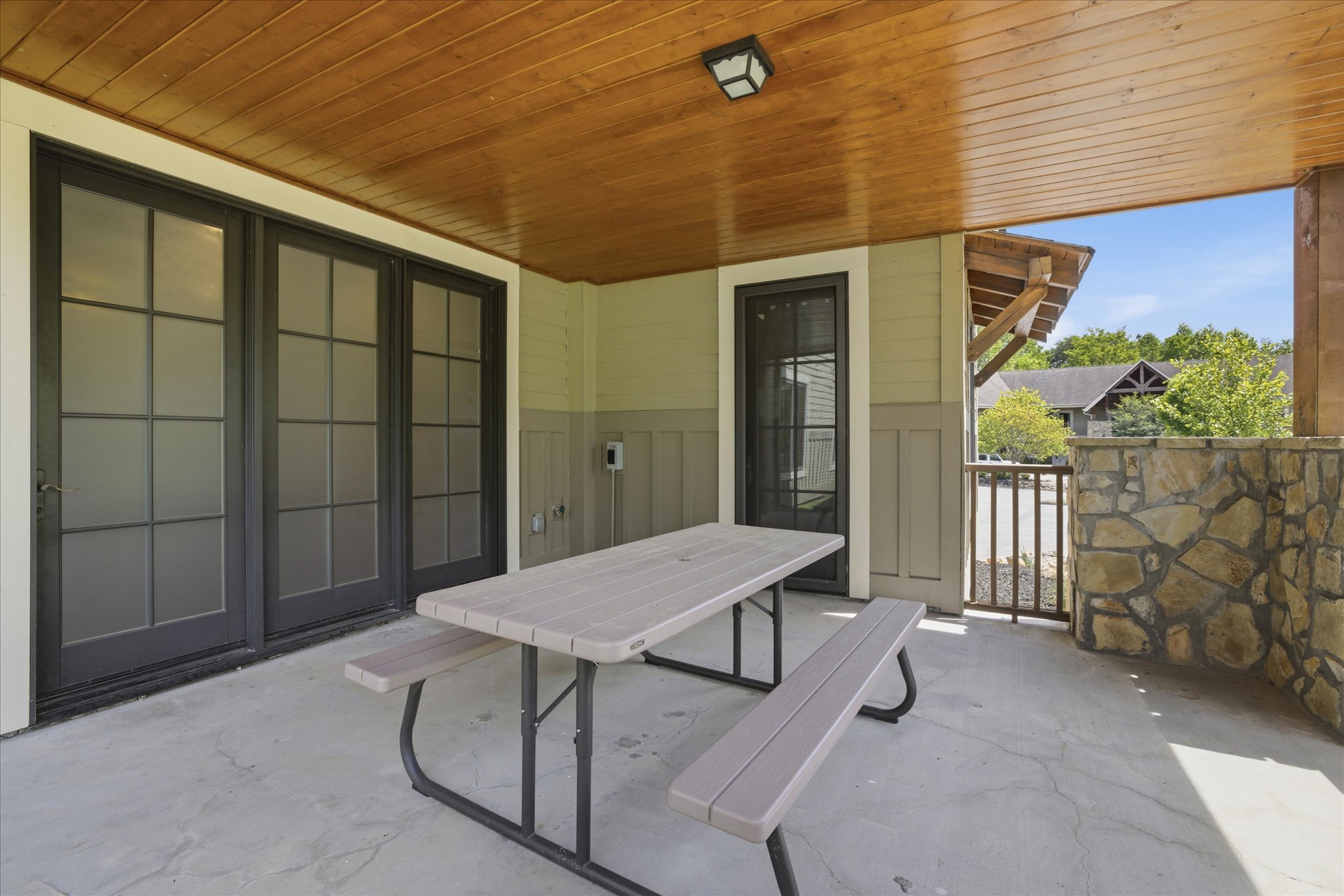 Step out onto the spacious back porch, where a picnic table invites you to gather for meals, morning coffee, or quiet moments surrounded by fresh air.
