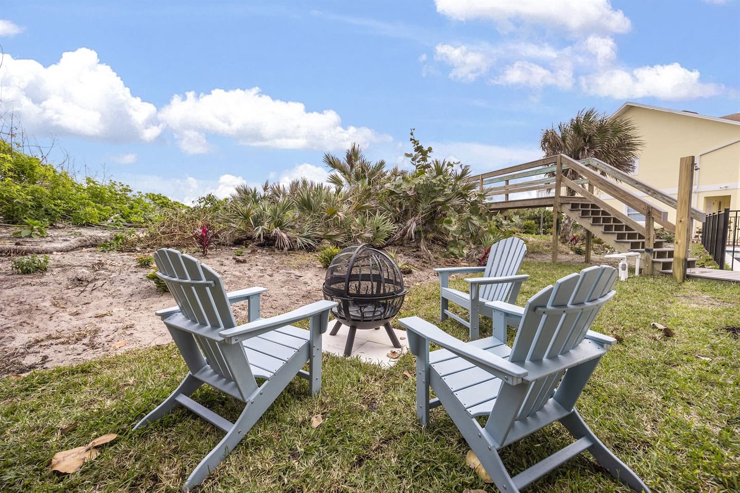 Relax in the outdoor space with beautifully decorated chairs at the center, surrounded by lush greenery. Enjoy stunning views of the neighborhood, with a charming bridge leading to the sea, creating the perfect spot for relaxation and sightseeing
