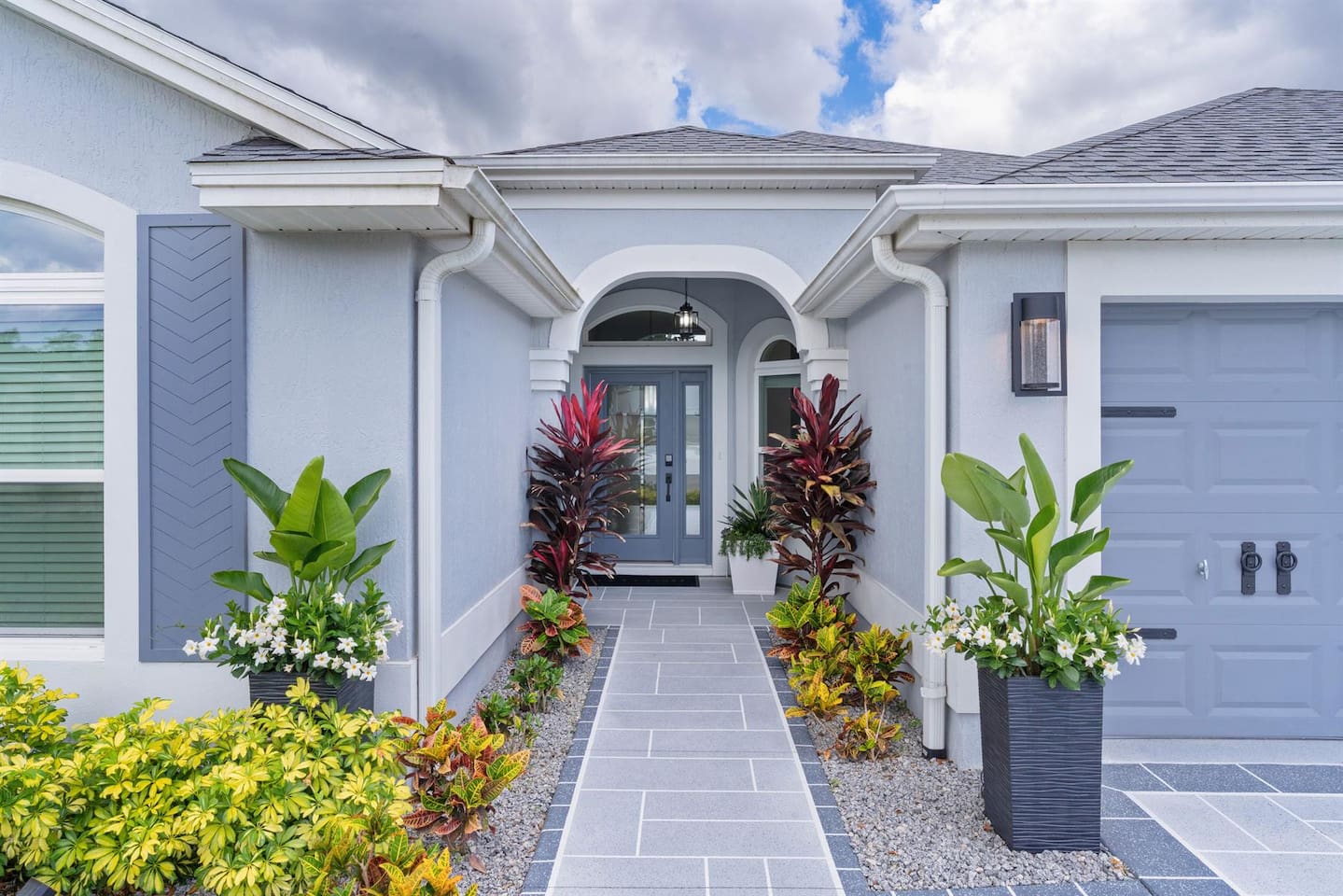Elegant front entryway with lush landscaping