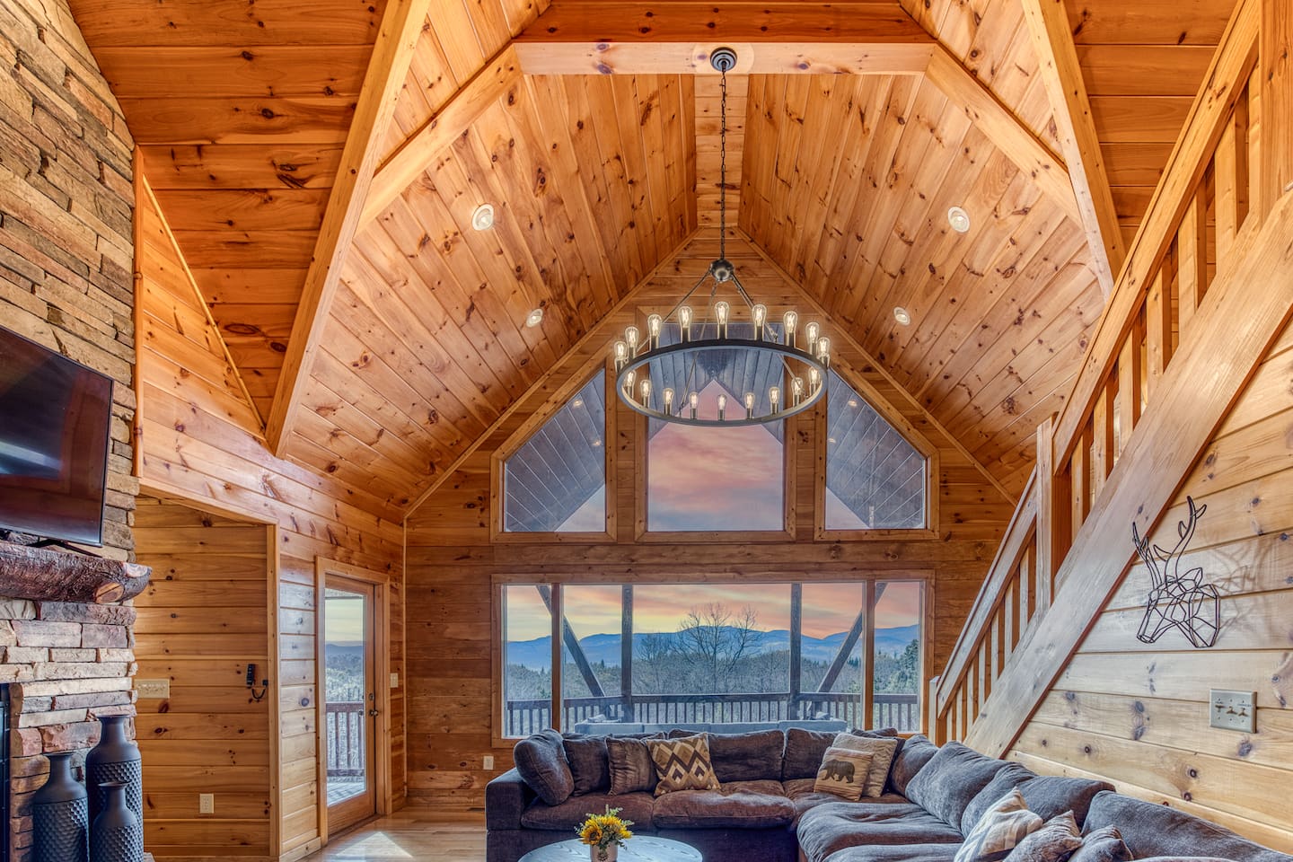 Main living room with beautiful A-frame ceiling, wall of windows, double-sided gas fireplace, and stunning mountain views! 