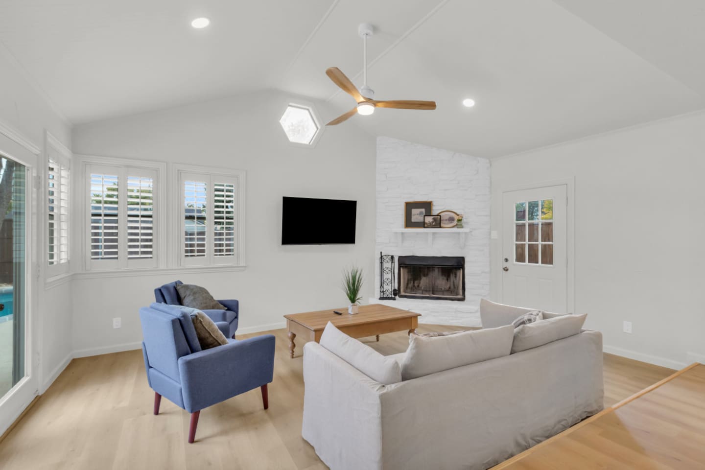 Cozy private living room with comfortable seating, large TV, and plenty of natural light. Stay cool with air conditioning and a modern ceiling fan.