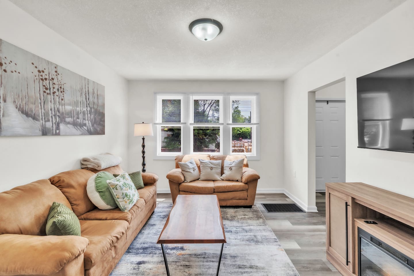Enjoy a relaxing atmosphere in the living room with comfortable couches, natural light from the large window, and a TV for your leisure.

