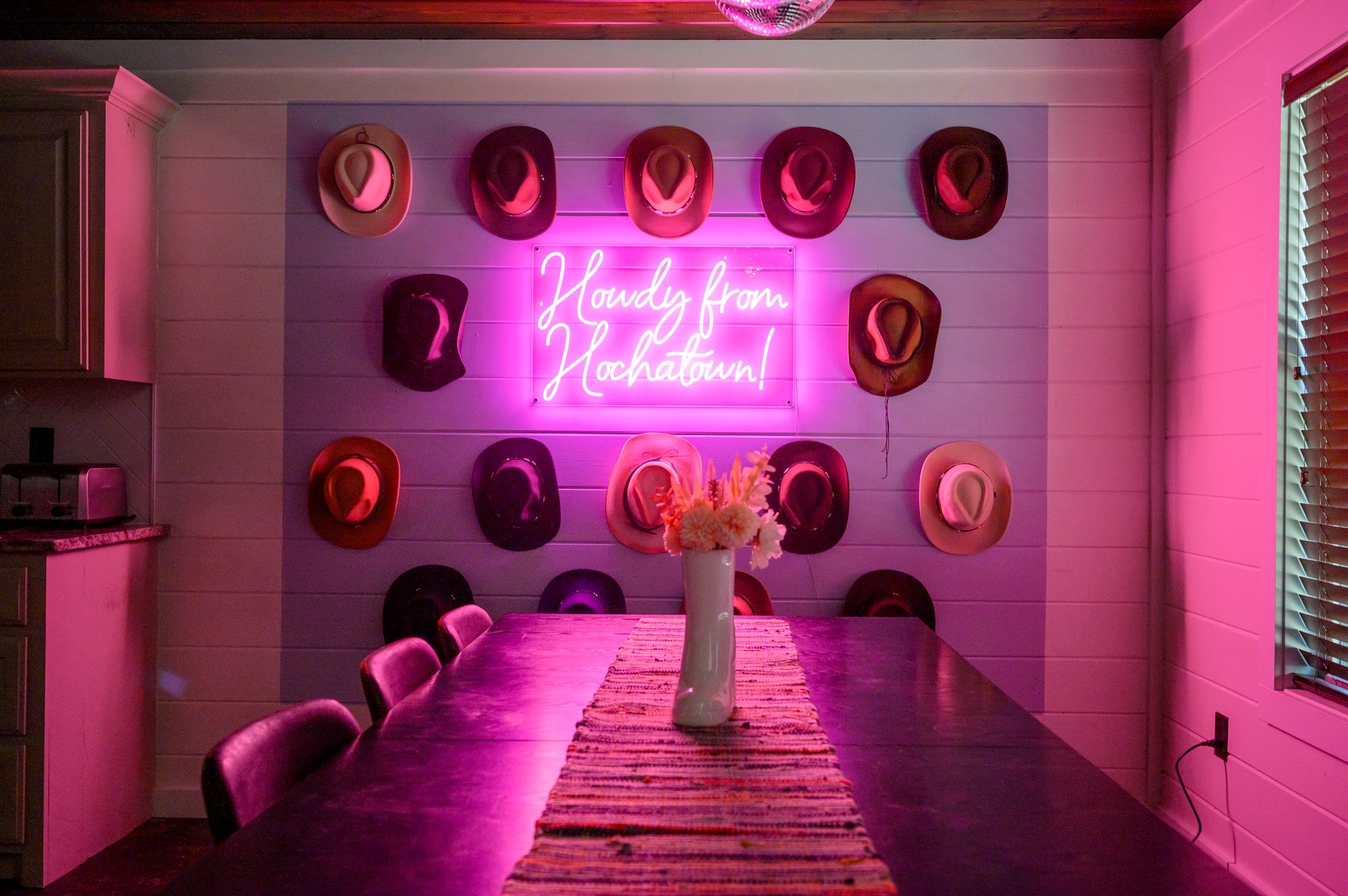 The neon light softly glows over the dining area, adding a unique flair to your meals and bringing a fun vibe to the space.