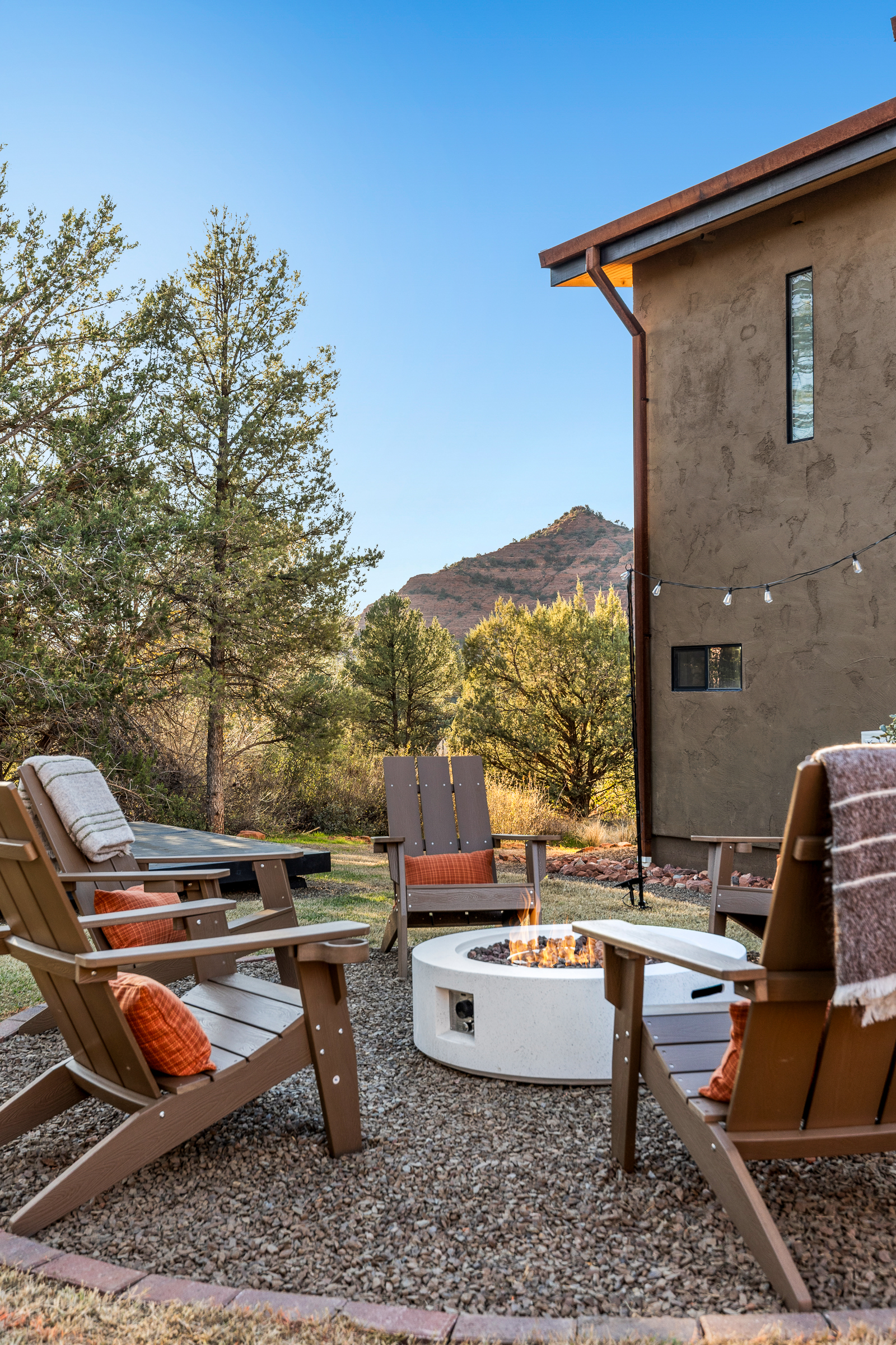 Settle into Adirondack chairs as the fire flickers, surrounded by desert trees and calm - an inviting space for conversation and evening unwinding.