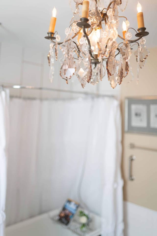 Indulge in a relaxing soak in your authentic 100+ year old clawfoot bathtub, Enjoy a complimentary bubble bath under the glow of a stunning crystal chandelier for the ultimate spa-like experience.
