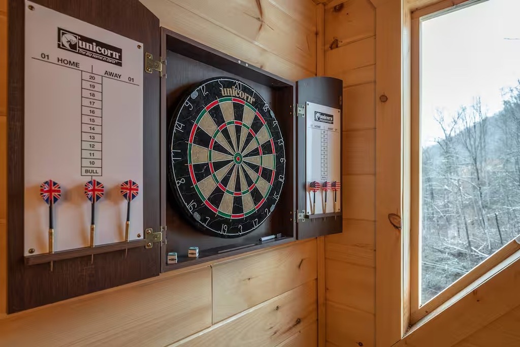 Challenge the kids to a game of darts in the entertainment room at Bear Paws Cabin. A Unicorn dartboard with full scoring setup keeps friendly family competition going all week long. Just one of the indoor amenities that makes Bear Paws a top-rated cabin