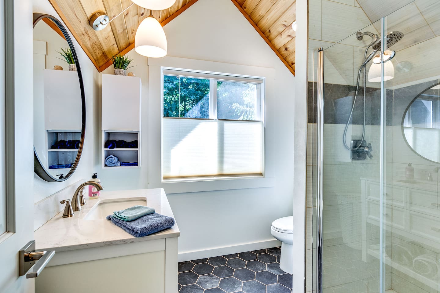 Upstairs bath with tall shower and tons of natural light. Keep the top down/bottom up blinds half-way down and look into the canopy of of the evergreen trees.