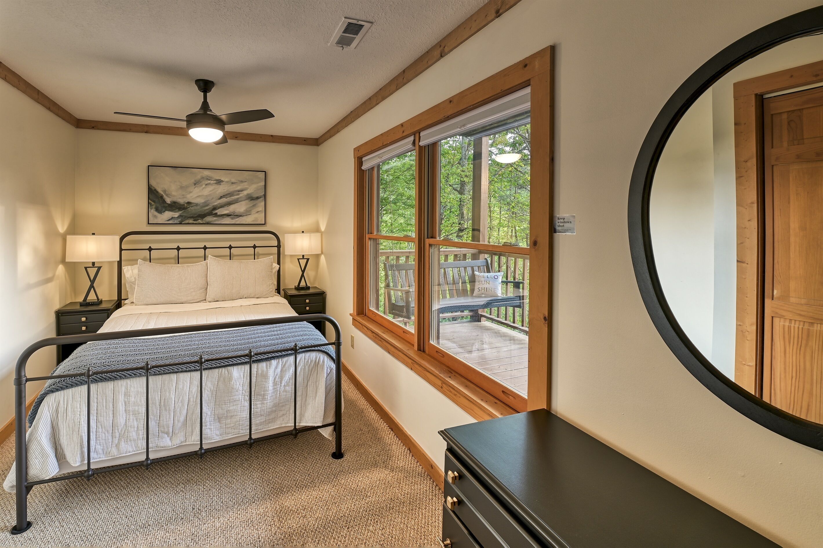 Basement level queen bedroom has a ceiling fan, dresser, closet and usb ports built into the touch lamps next to the bed.