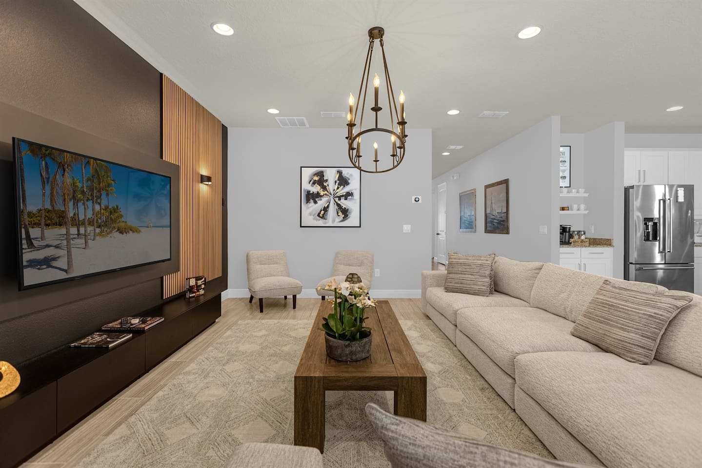 From another angle, the living room reveals its airy layout, with a sleek sofa facing the smart TV and a chic coffee table in the center. Large windows bring in ample sunlight, highlighting the room’s modern décor and inviting atmosphere.