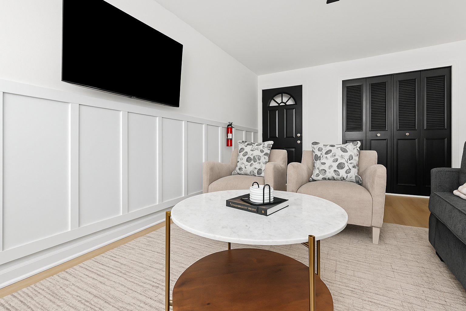 Enjoy a bright and airy space with elegant wall paneling, a mounted Smart TV, and modern furnishings.