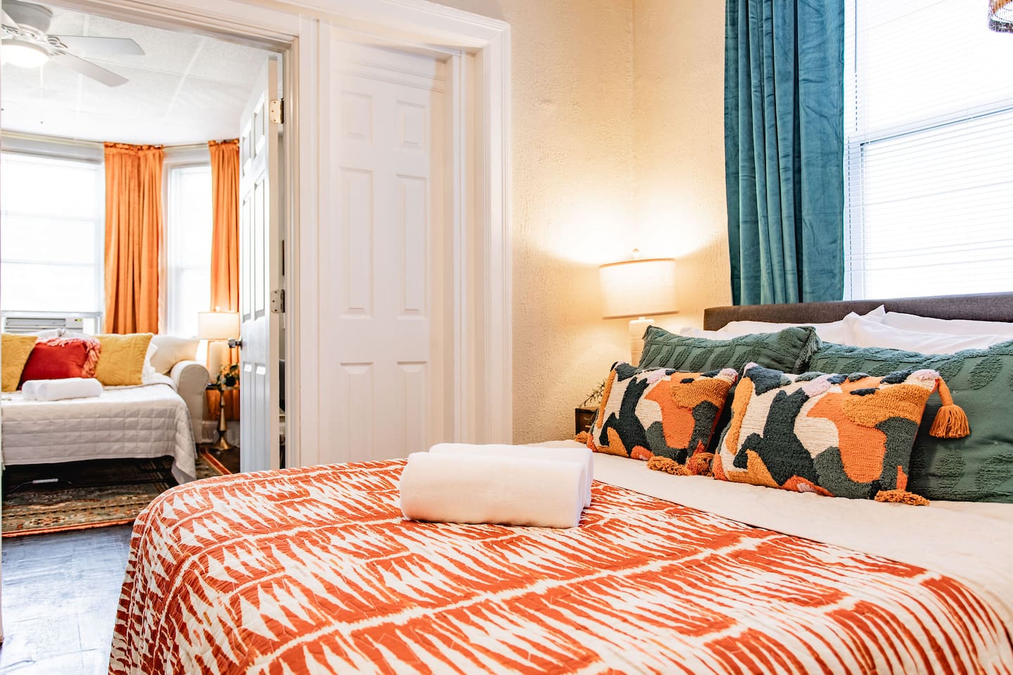 Spacious bedroom with a cozy living room area on the side, creating a seamless flow between both spaces for relaxation and comfort.