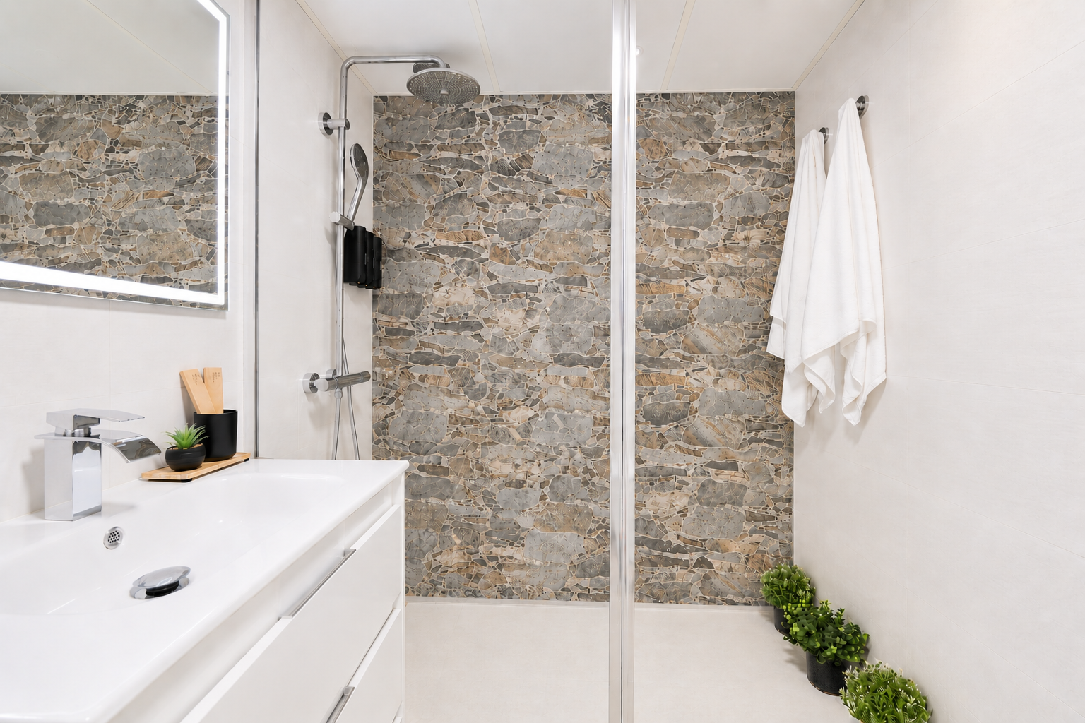 Modern bathroom with walk-in rain shower, stone accent wall, LED mirror, and fresh spa-like touches for your comfort.