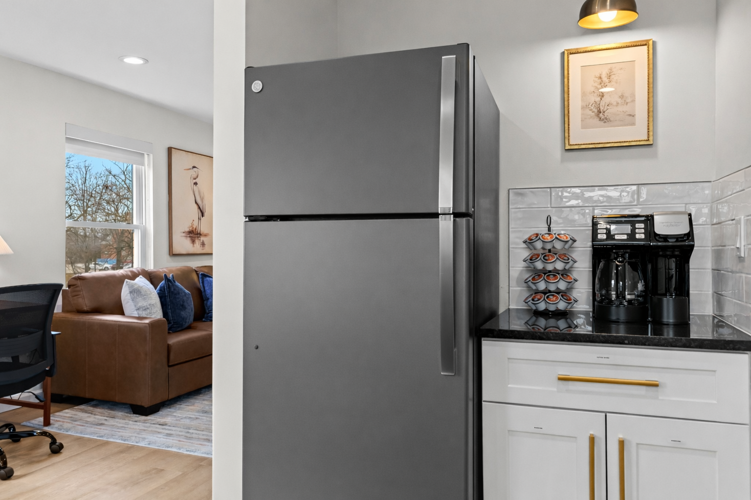 Convenient kitchen nook with full-size fridge, coffee station, and extra storage—perfect for morning routines and keeping everything organized.