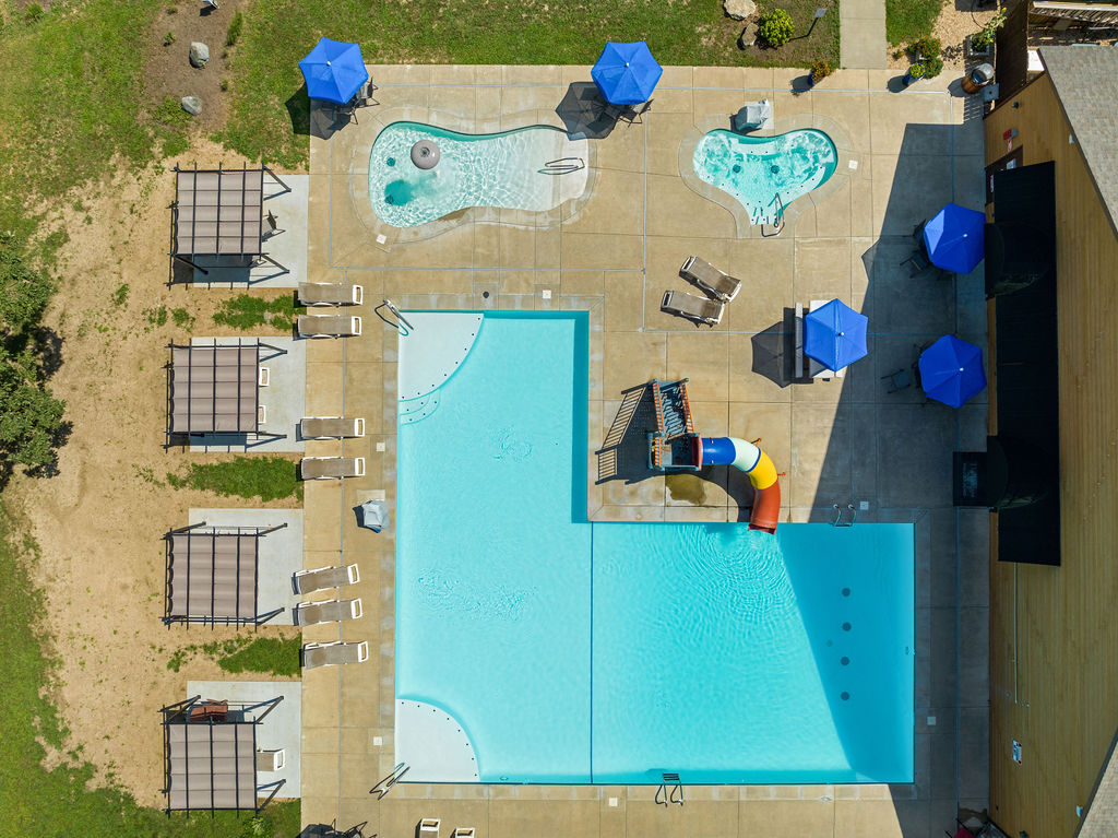 
☀️ Resort-style outdoor pool with waterslide, hot tubs, and plenty of lounge seating