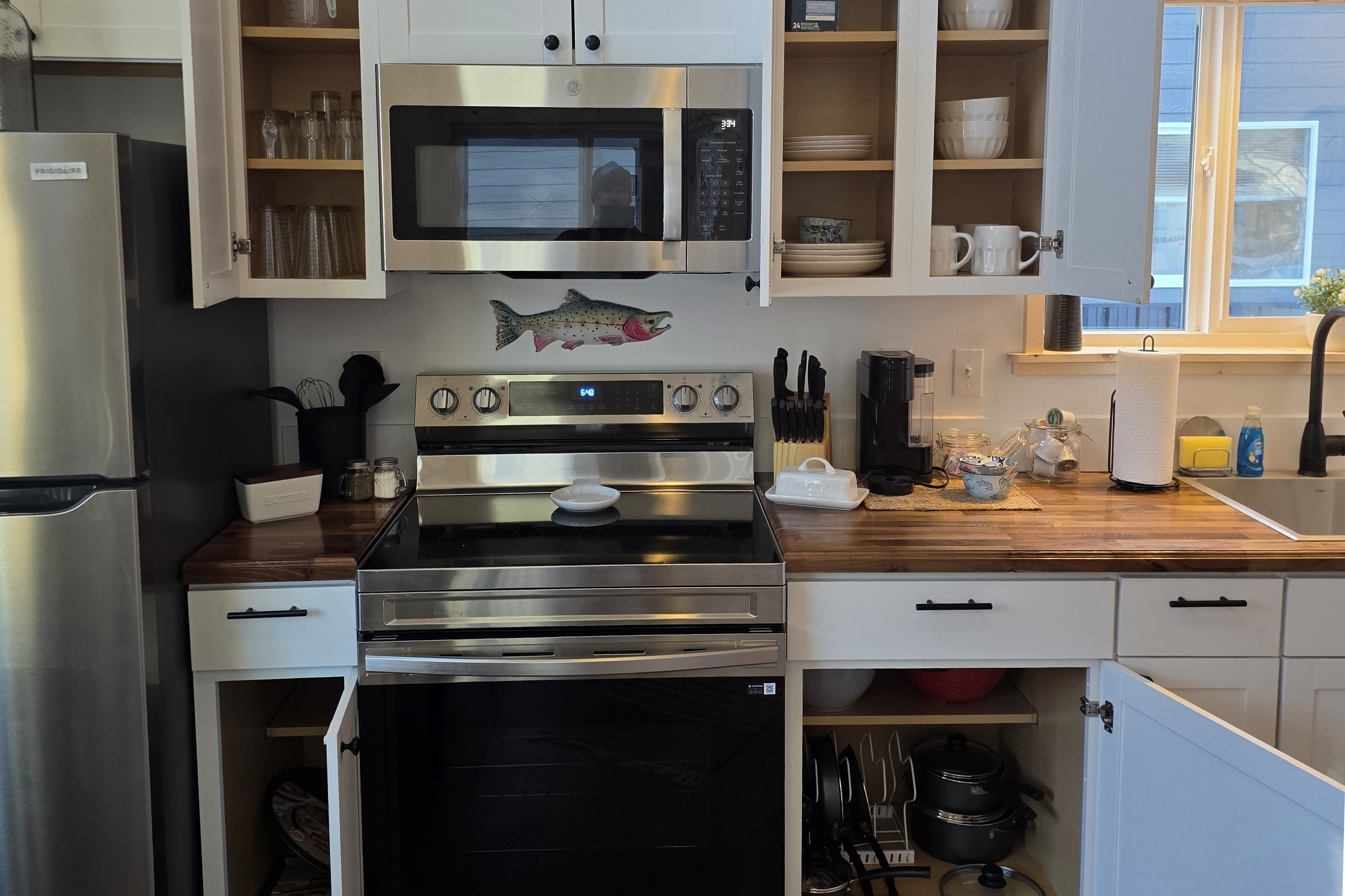 Fully stocked kitchen includes an electric range, microwave, refrigerator,  and Keurig .