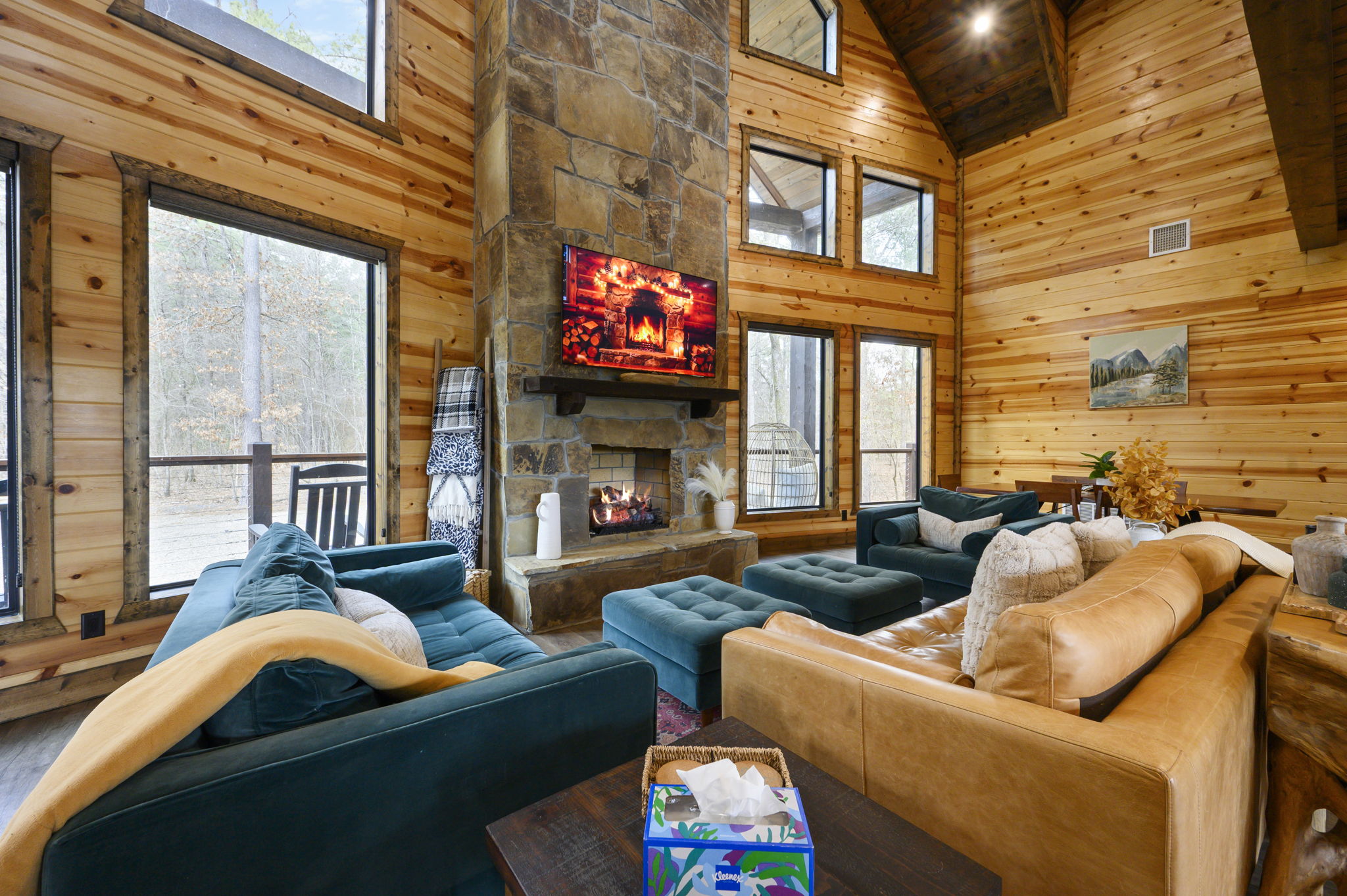 Soaring windows frame the pond outside while warm wood and stone invite you to gather and relax.