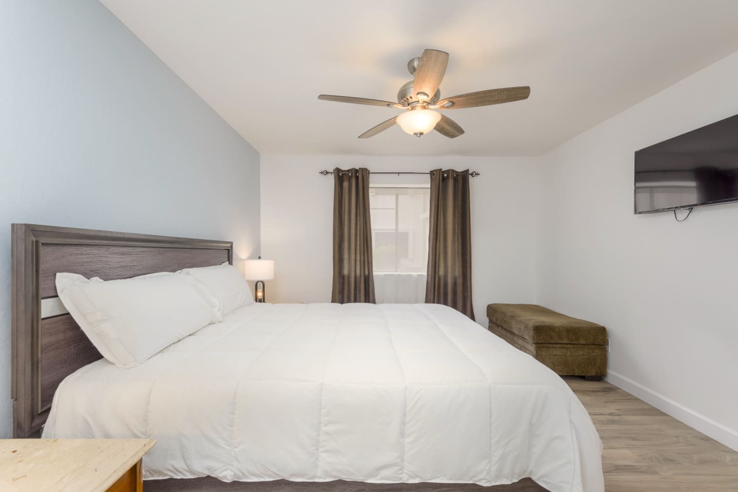 King bedroom with soft bedding, bedside lamps, and a simple place to relax at the end of the day.
