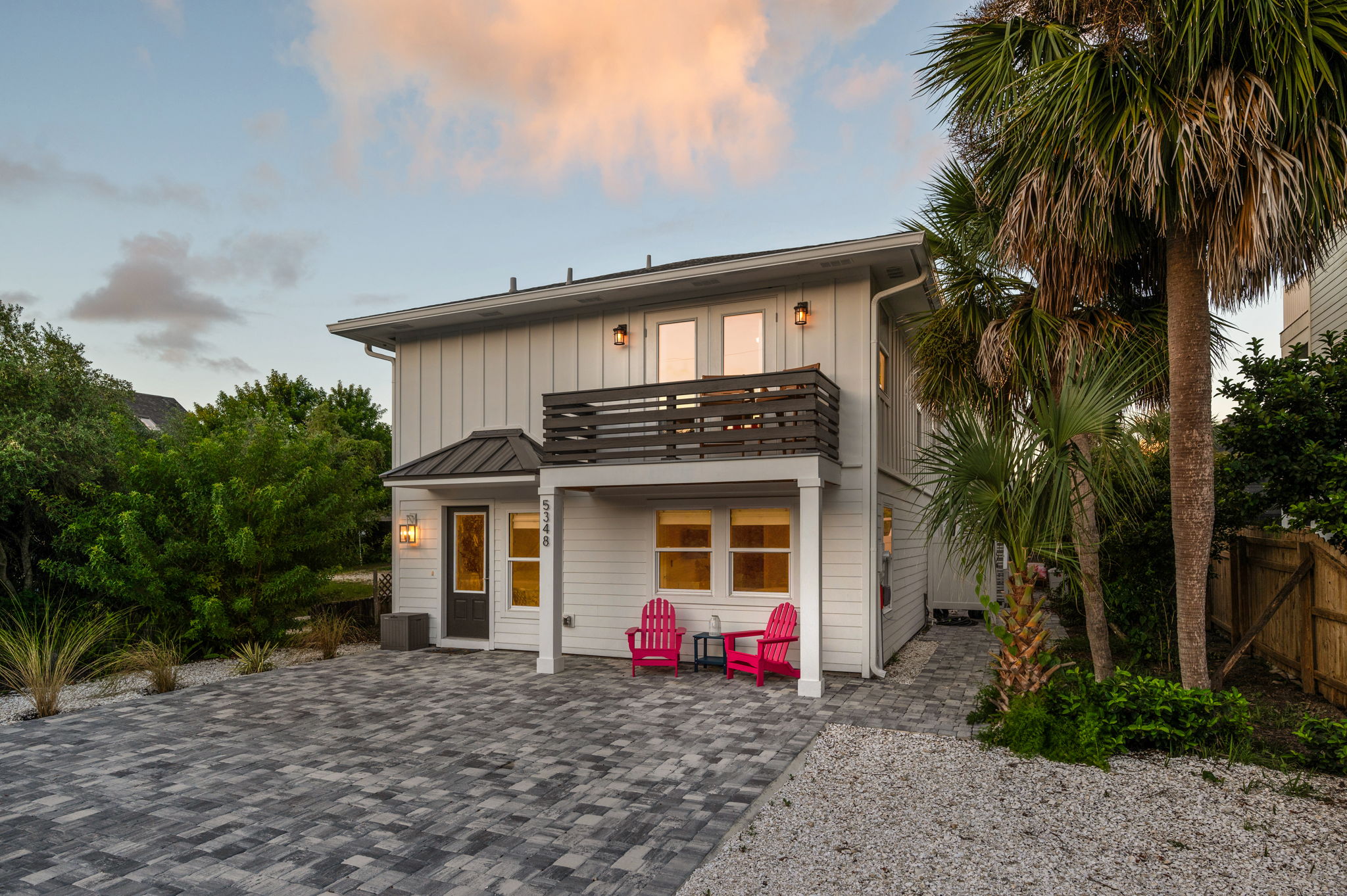 An exquisite sunset view of the house, with golden tones and soft pink clouds creating a serene and stunning backdrop.