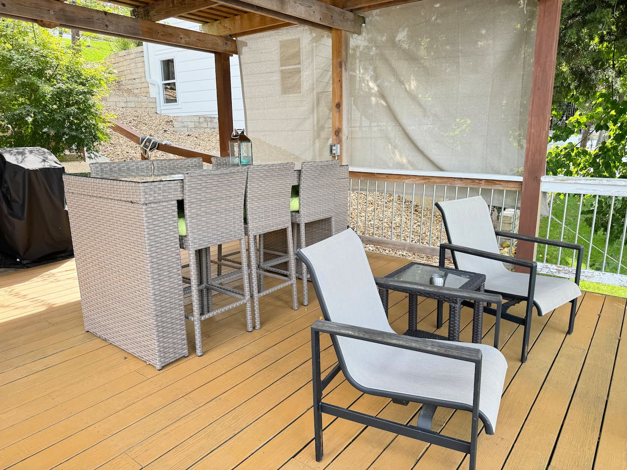 Covered patio with high top table seating for 6 and two chairs. 