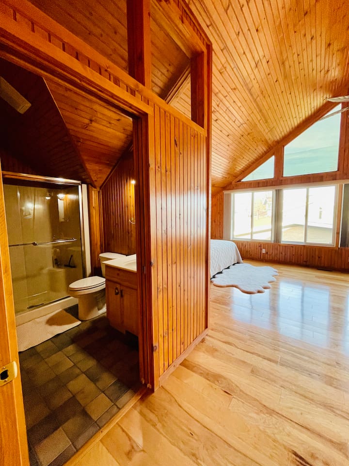 Bright big master bedroom with a panoramic lake view.