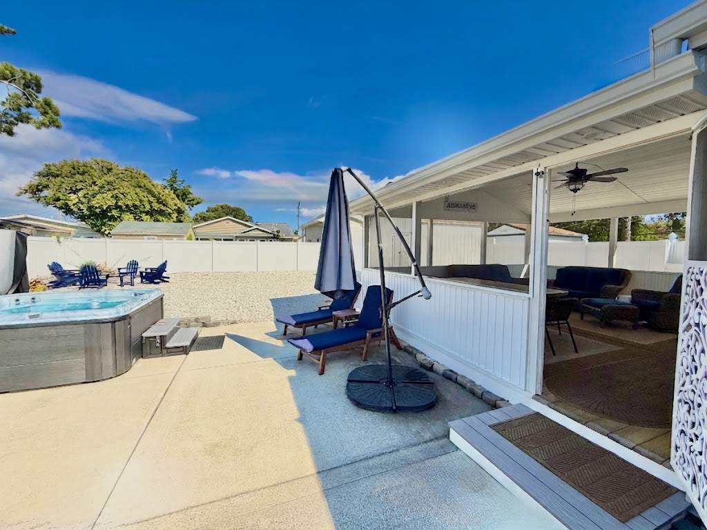 Maximize your vacation in our fully equipped backyard. Features include a gas grill, patio dining for four under a blue umbrella, lounge chairs for sunbathing, and a relaxing hammock. The perfect setup for a summer afternoon BBQ!