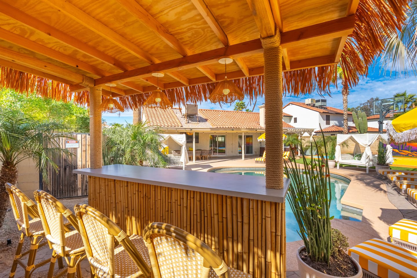 Tiki-style outdoor bar with lounge seating and pool views—your private resort oasis for sunset drinks and good company.