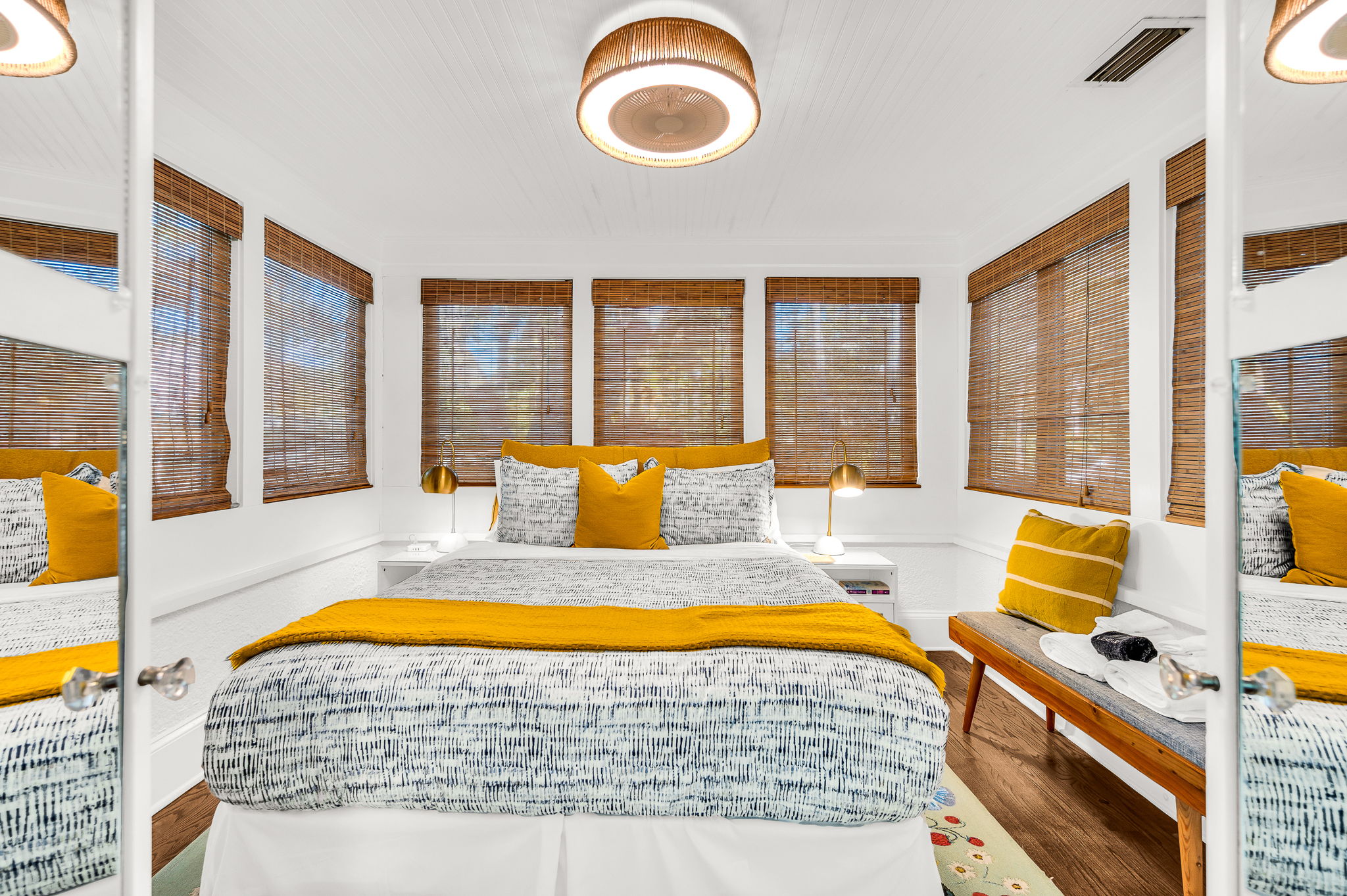 Charming first-floor queen bedroom just off the main living area, featuring a queen bed, a smart TV,  bamboo shades, and French doors that fill the room with natural light.
